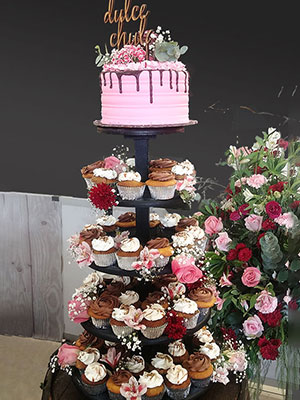 Torre de cupcakes y flores con pastel simbolíco